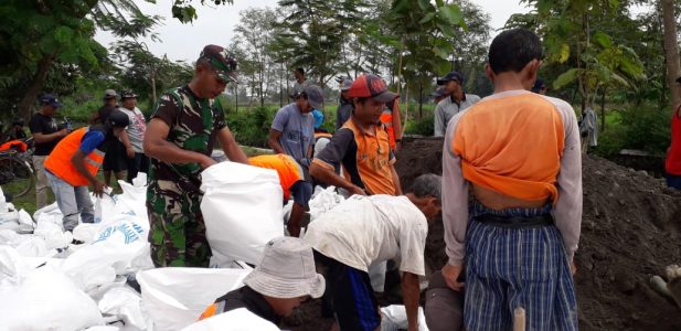 Anggota Koramil Gantiwarno Bersama  Warga Desa Jabung Perbaiki Tanggul Jebol