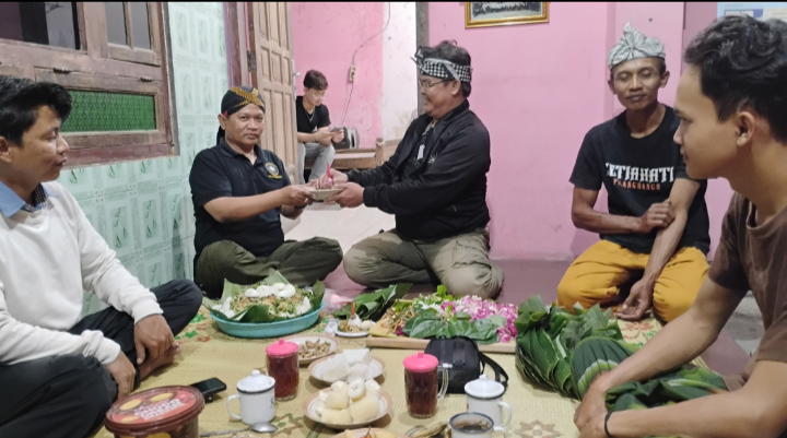 Ketua Cabang PSH Pilangbango Sukoharjo menyerahkan potongan tumpeng kepada perwakilan Cabang Surakarta pada Malam Tirakatan 1 Suro 2026 sebagai simbol persaudaraan dan kebersamaan. (Foto: Redaksi).